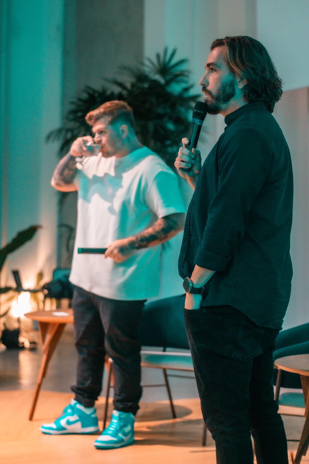 Nelson speaking with a microphone on stage alongside Bernard de Luna