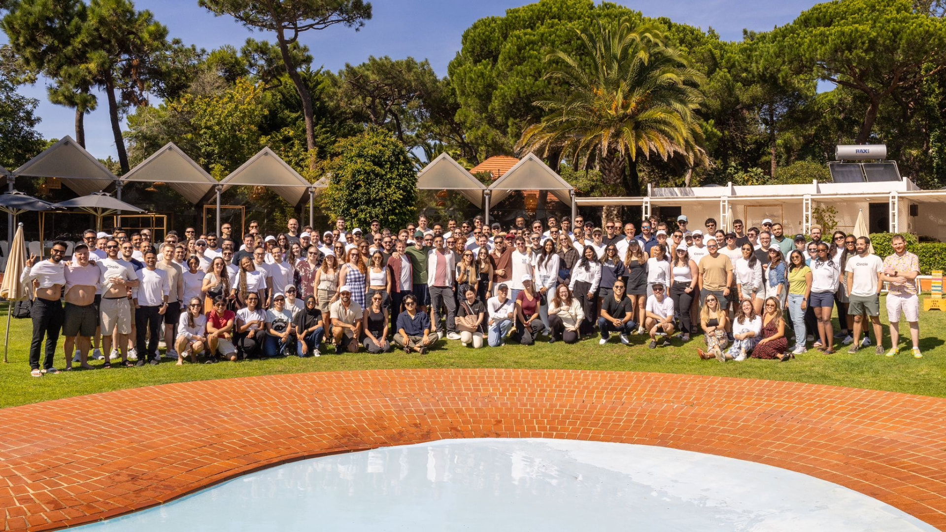 Large company offsite group photo beside a pool