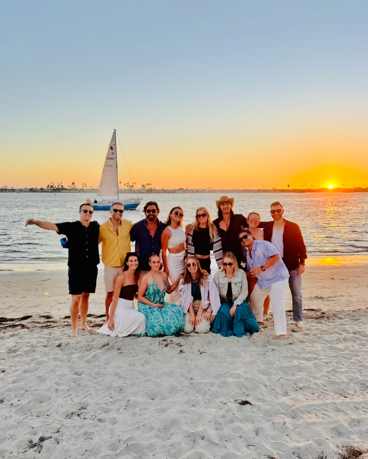 Nelson with a group of friends on the beach at sunset