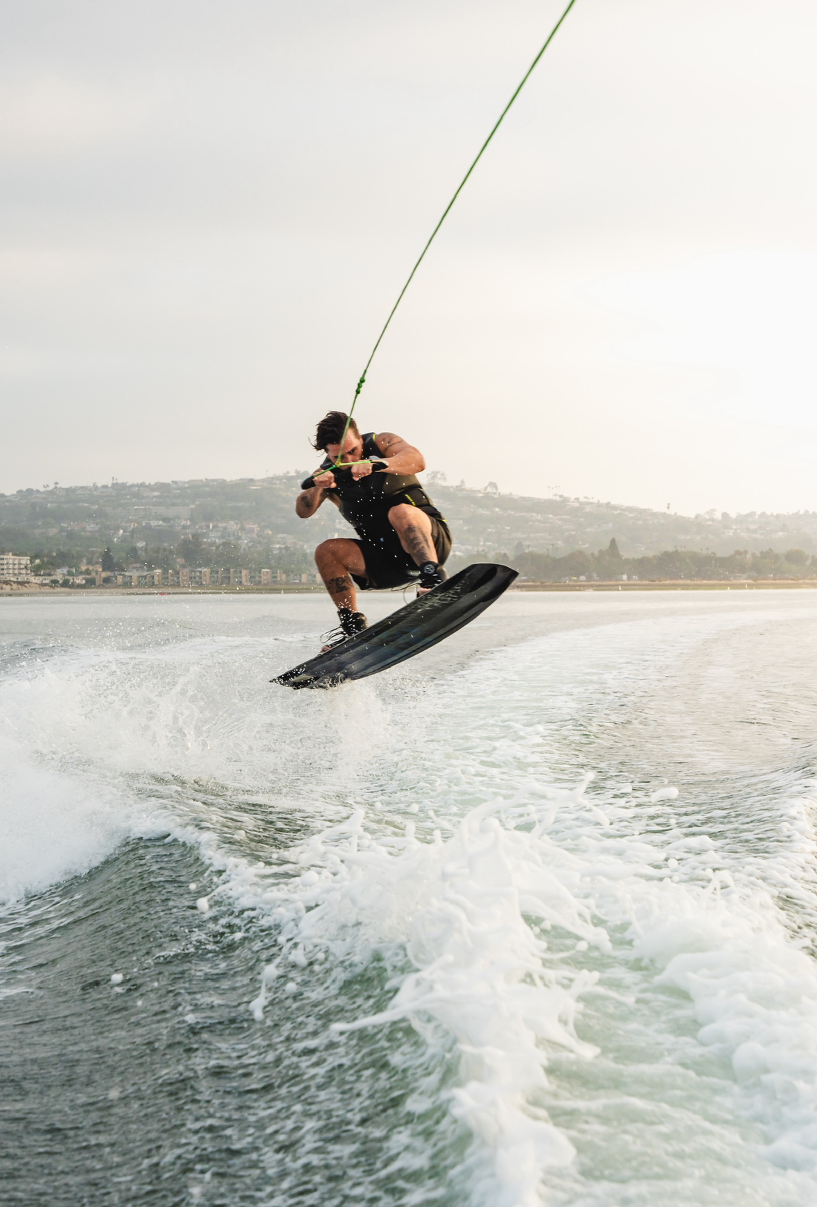 Nelson mid-air on a wakeboard behind a boat