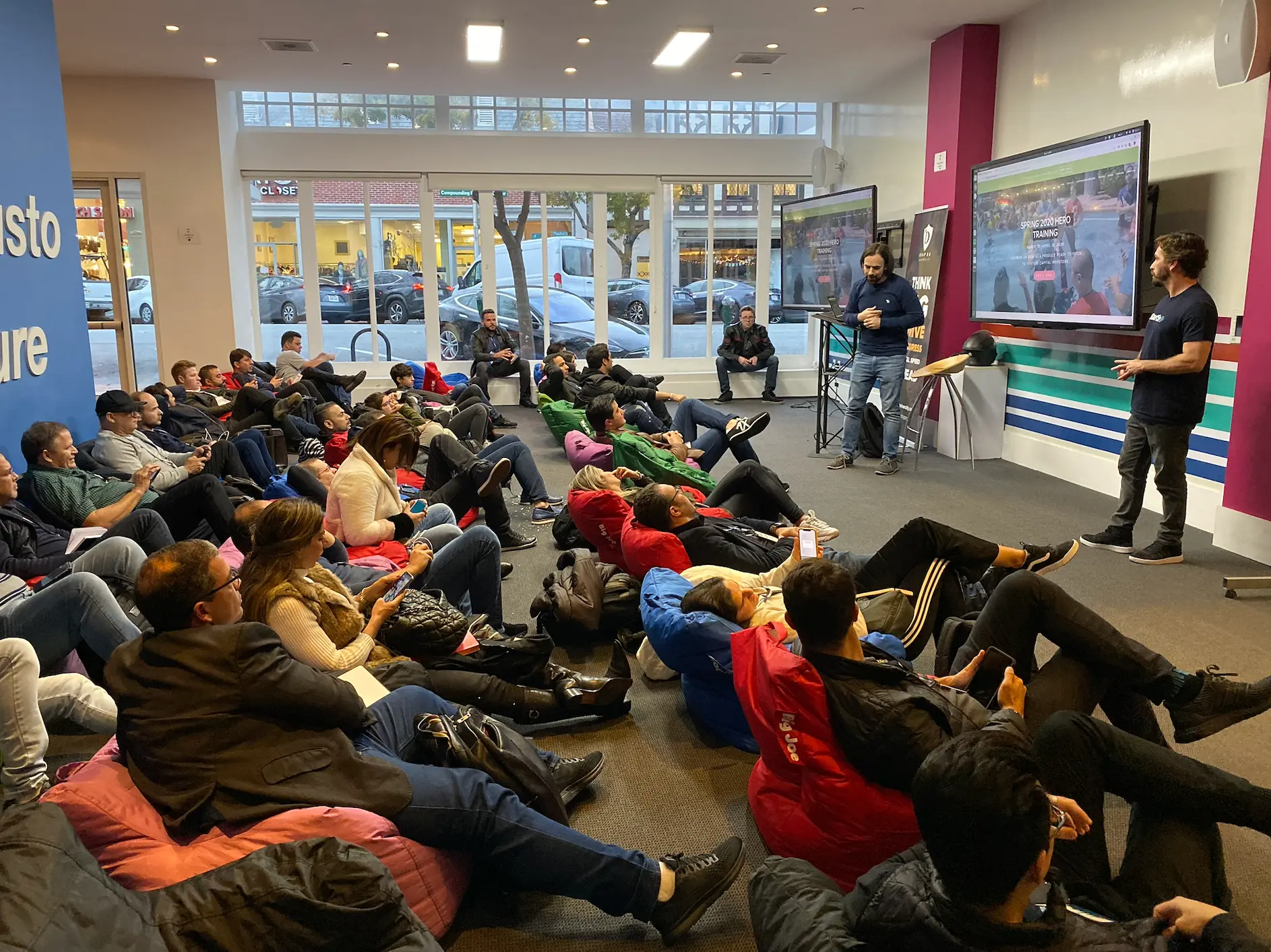 Speaking to an audience seated on bean bags at a startup event