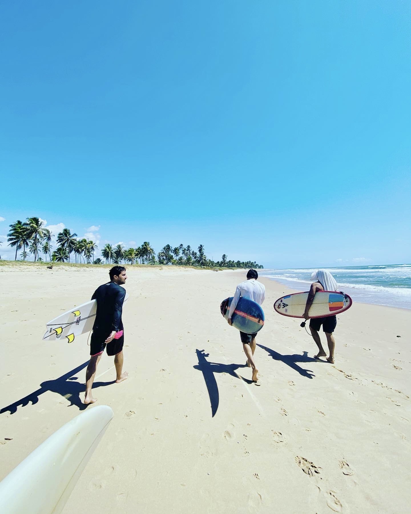Nelson and friends walking a Brazilian beach with surfboards