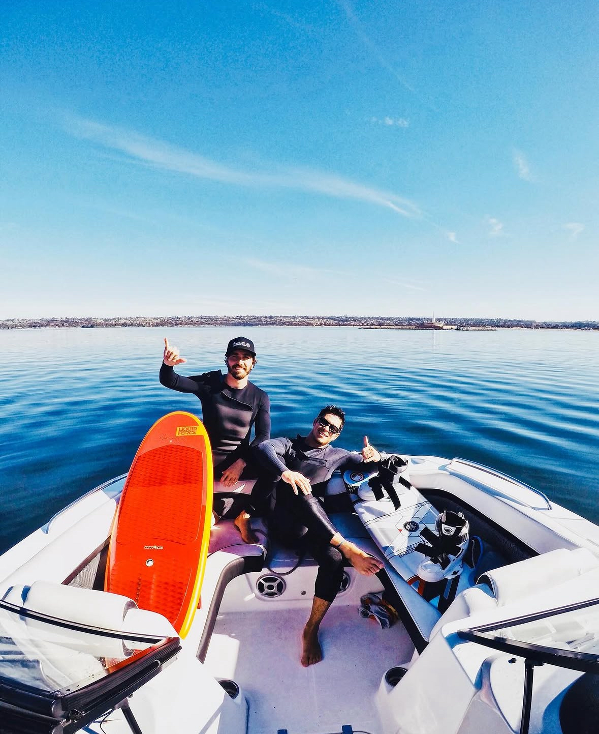 Nelson and a friend on a boat with wakeboards